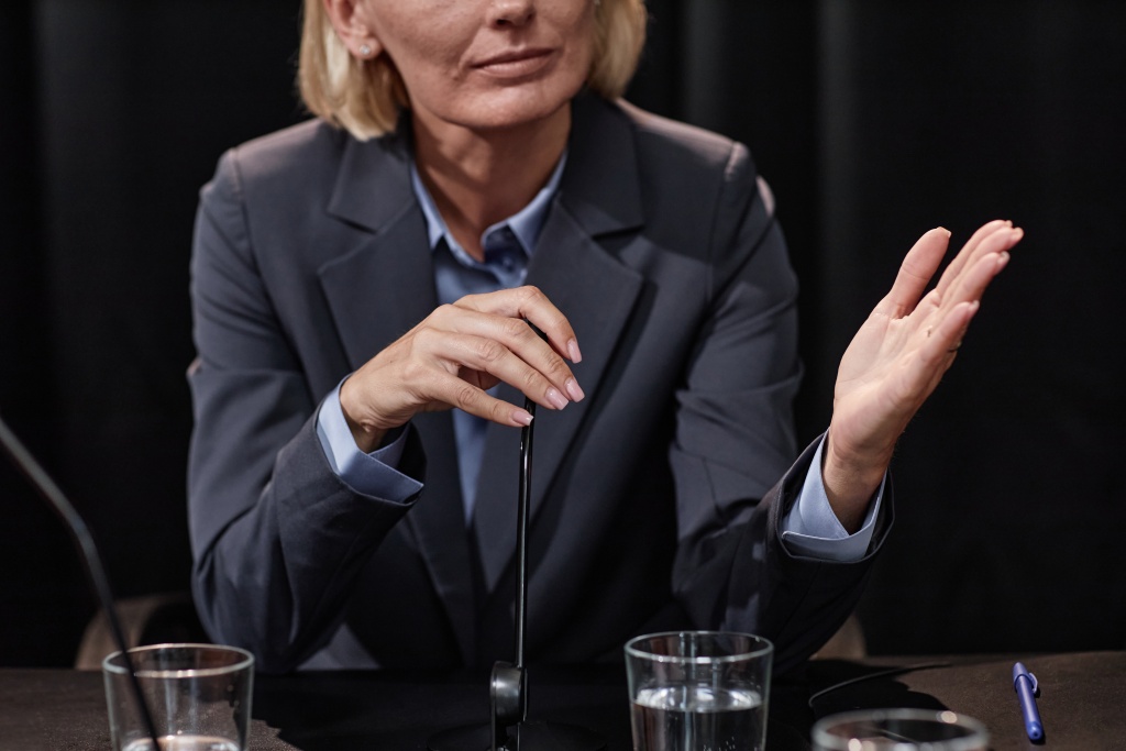 female-politician-adjusting-mic-while-participating-debate-press-conference.jpg решение спора